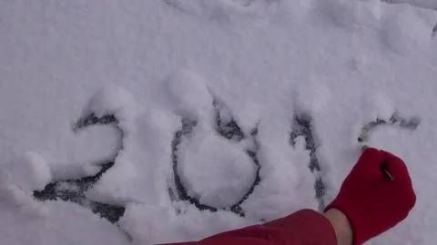 Hand with red glove and painter brush write number 2018 on fresh snow 库存影片 72931736