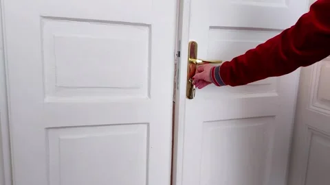 Hand in Red Shirt Opens White Door with Gold Handle Vidéo 329904377