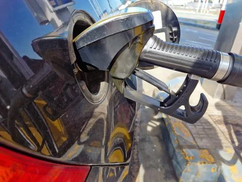 Hand refilling the car with fuel, close-up. Stock Photos
