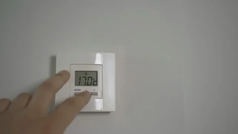 Hand regulates heating temperature at home Stock Footage 274500576