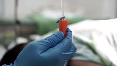 A hand regulating the intravenous fluid of a patient. Stock Footage 101102907