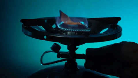 Hand regulating the supply of burning liquefied gas Stock Footage 220736668