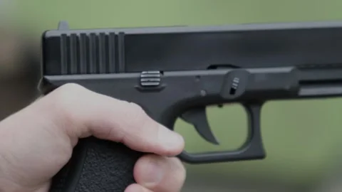 A hand reloads a pistol or cocks the pistol and fires a shot, a close-up of the Stock Footage 320634194