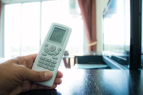Hand with remote control directed on the conditioner Stock Photos