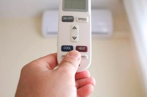 Hand with remote control directed on the conditioner Stock Photos