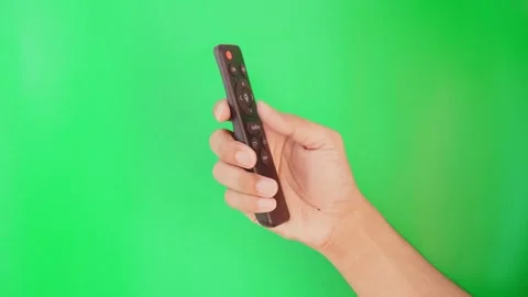 Hand with remote control turns on TV through green screen. Stock Footage 305689207