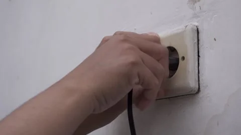 A hand remove an electrical plug from a wall socket Stock Footage 283268808
