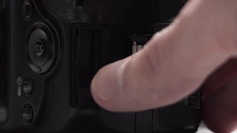 The hand removes and inserts the SD memory card in the camera. Stock Footage 128700768