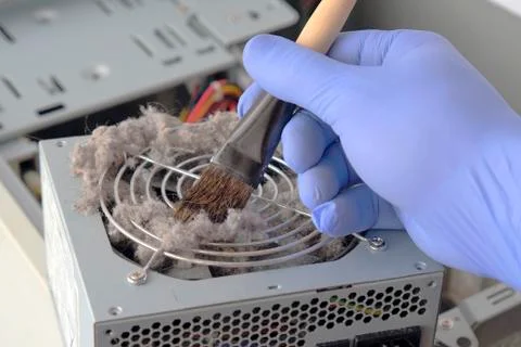 Hand removes dust from computer Fotos de archivo
