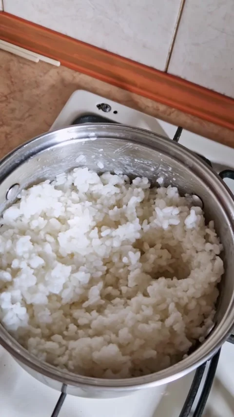 Hand removes lid from pot of cooked white rice Stock Footage 319029528
