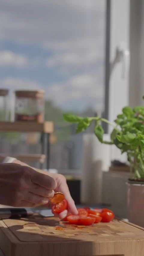 Hand removes pulp from cut tomato with small spoon on cutting board Stock Footage 344055409