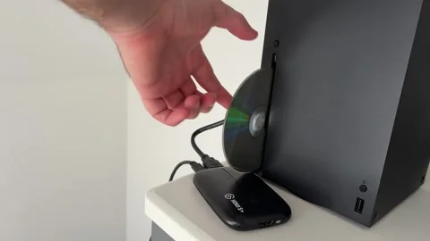 Hand Removing Disc From Xbox Console Beside TV Stand Stock Footage 337506436