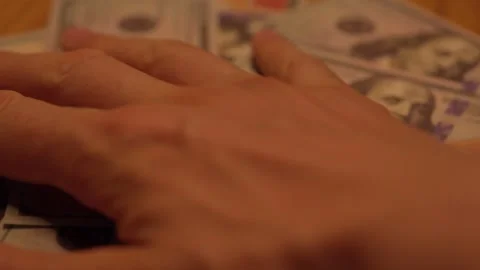 Hand removing dollar bills from table 動画素材 345022425