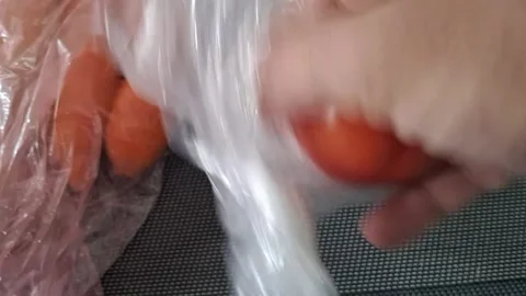 Hand removing fresh raw carrots from plastic bag motion video clip Stock Footage 336276913