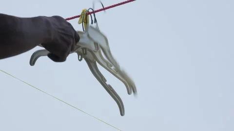 Hand Removing Plastic Clothes Hangers from an Outdoor Laundry Line Stock Footage 342256820