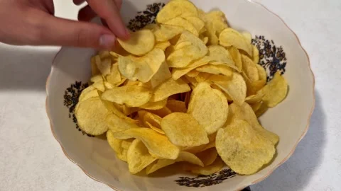 Hand Repeatedly Taking Crispy Potato Chips from a Bowl Stock Footage 344577507