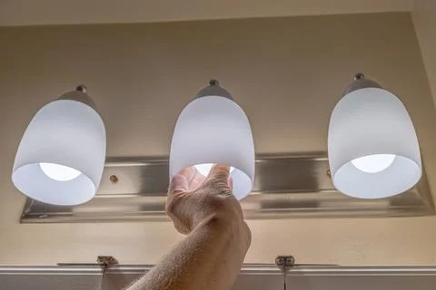 Hand Replacing Bathroom Vanity Light Bulb Stock Photos
