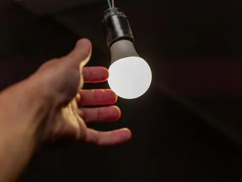 Hand replacing electric bulb Stock Photos