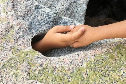Hand request help from big stone hole. Foto stock