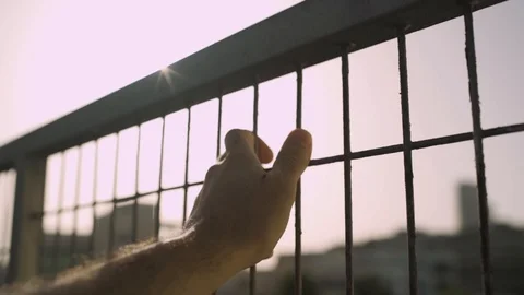 Hand resting on a rustic fence with the sun shinning through Stock Footage 109164444