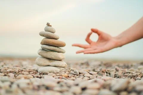A hand is resting on a stack of rocks Stock Photos