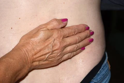 Hand resting on swelling of the back Stock Photos