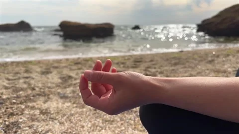 Hand rests in meditative pose on sandy beach. Calm and peaceful mind concept Stock-Footage 337219976