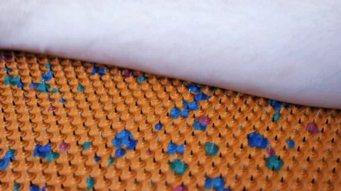 The hand rests on a needle acupuncture mat. Sharp iron needles on a rubber sheet Stock Footage 236357484