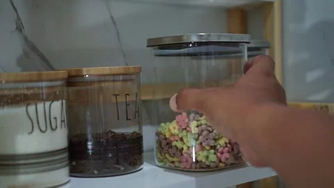 Hand returning colorful cereal jar to wooden rack, Stock Footage 345293589