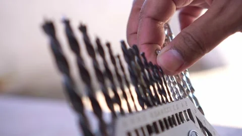 Hand returning drill bit to organizer case, close up shot, various size drill Stock Footage 345293528