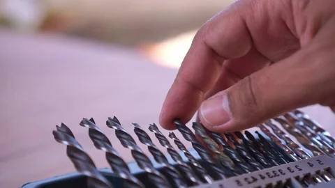 Hand returning steel drill bit to storage container, close up shot, hardware Stock Footage 345289126
