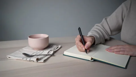 Hand returning to writing after coffee break Video stock 328003229