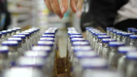 Hand with a ring of a customer taking couple bottles of beer from the row Stock Footage 166074126