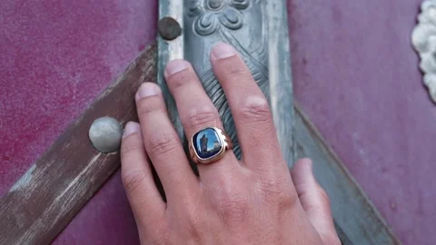 Hand with ring touches old texture grave door. Traditionally masculine jewelry Stock Footage 136233171