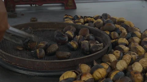 Hand roasting nuts in netted pan Stock Footage 65874323