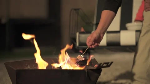 A hand roasts a marshmallow over an outdoor fire pit in Mendoza, Argentina Stock Footage 342342993