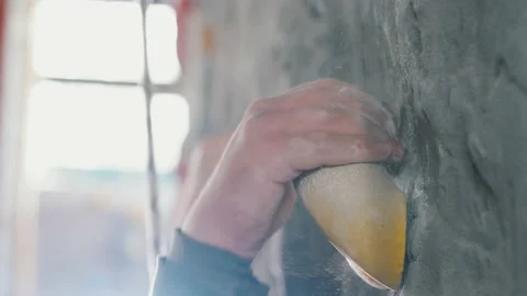 Hand of rock climber close-up, catching on the hook, talc powder flying away. Video stock 140799789