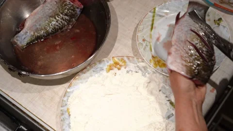 Hand rolling carp in meal and putting on frying pan. Vidéo 148991031