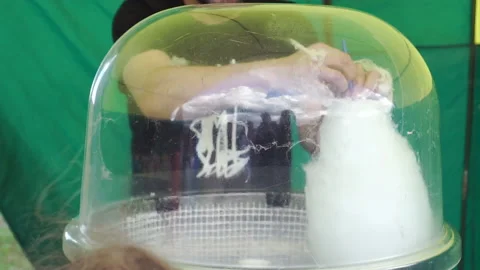 Hand rolling cotton candy in candy floss machine. Making candyfloss Stock Footage 202117429