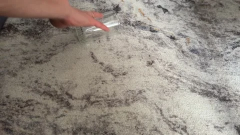 Hand rolling an empty glass across a stone floor surface Stock Footage 336976520