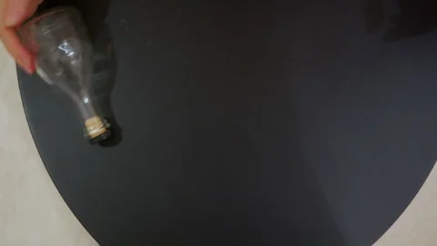 Hand Rolling Empty Glass Bottle on Table Top View Video stock 332672965