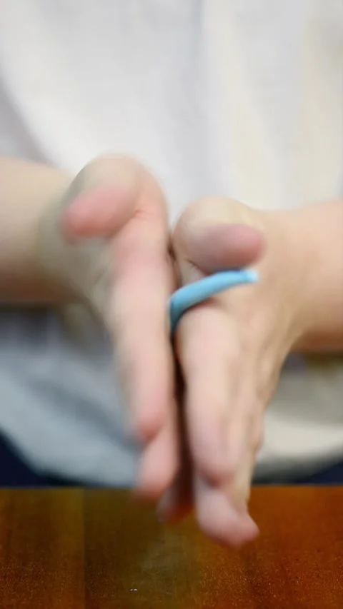 Hand rolling a piece of polymer clay into a long cylinder shape Stock Footage 342907460