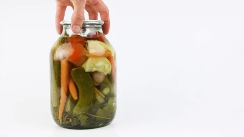Hand rotate jar with pickled vegetables, show contents, white background,closeup Видео 105104077