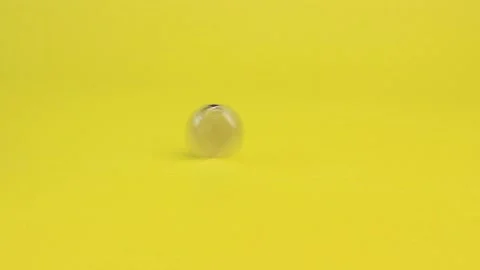 The hand rotates a coin on a yellow background. Stock Footage 162537065