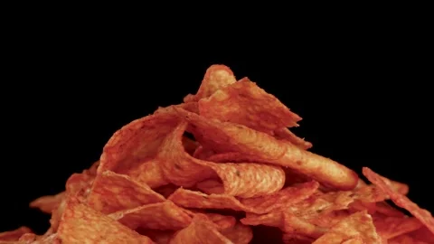 Hand Rotates Crispy Nacho Chips Pile on Black Background Stock Footage 322084467