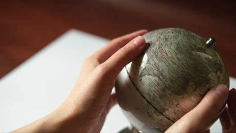Hand is rotating a gray Globe and selecting a random point on the map. World map Stock Footage 313108382