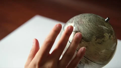 Hand is rotating a gray Globe and selecting a random point on the map. World map Stock Footage 313108460