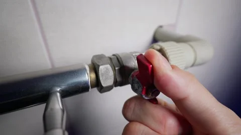 Hand Rotating Red Handle Ball Valve to Control Heating System in House Stock Footage 339211980