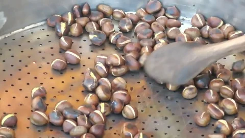 Hand rotating roast chestnuts Stock Footage 80857777