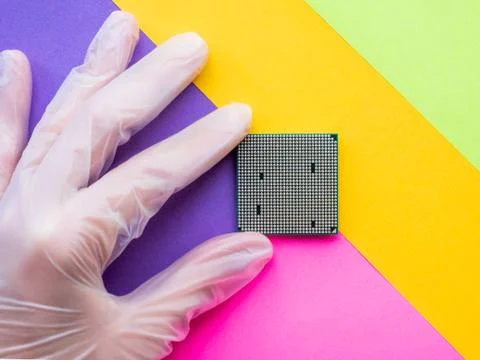 Hand in rubber glove with Central Computer Processor. CPU on geometric backgr Stock Photos